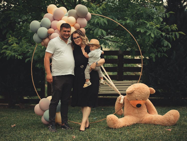 Family Posing With Toys In A Park