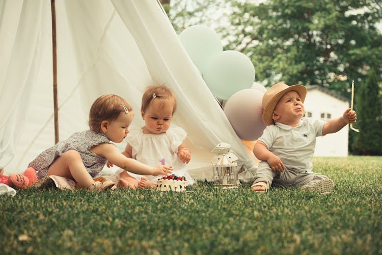 Babies Sitting In A Yard