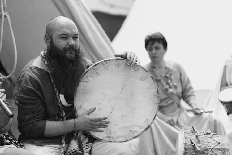 Bearded Man Playing On Traditional Drum