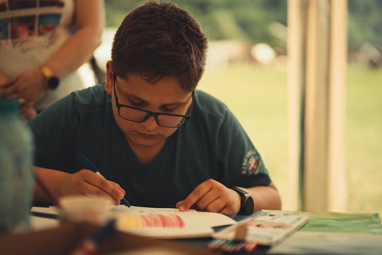 A Boy Writing On Paper