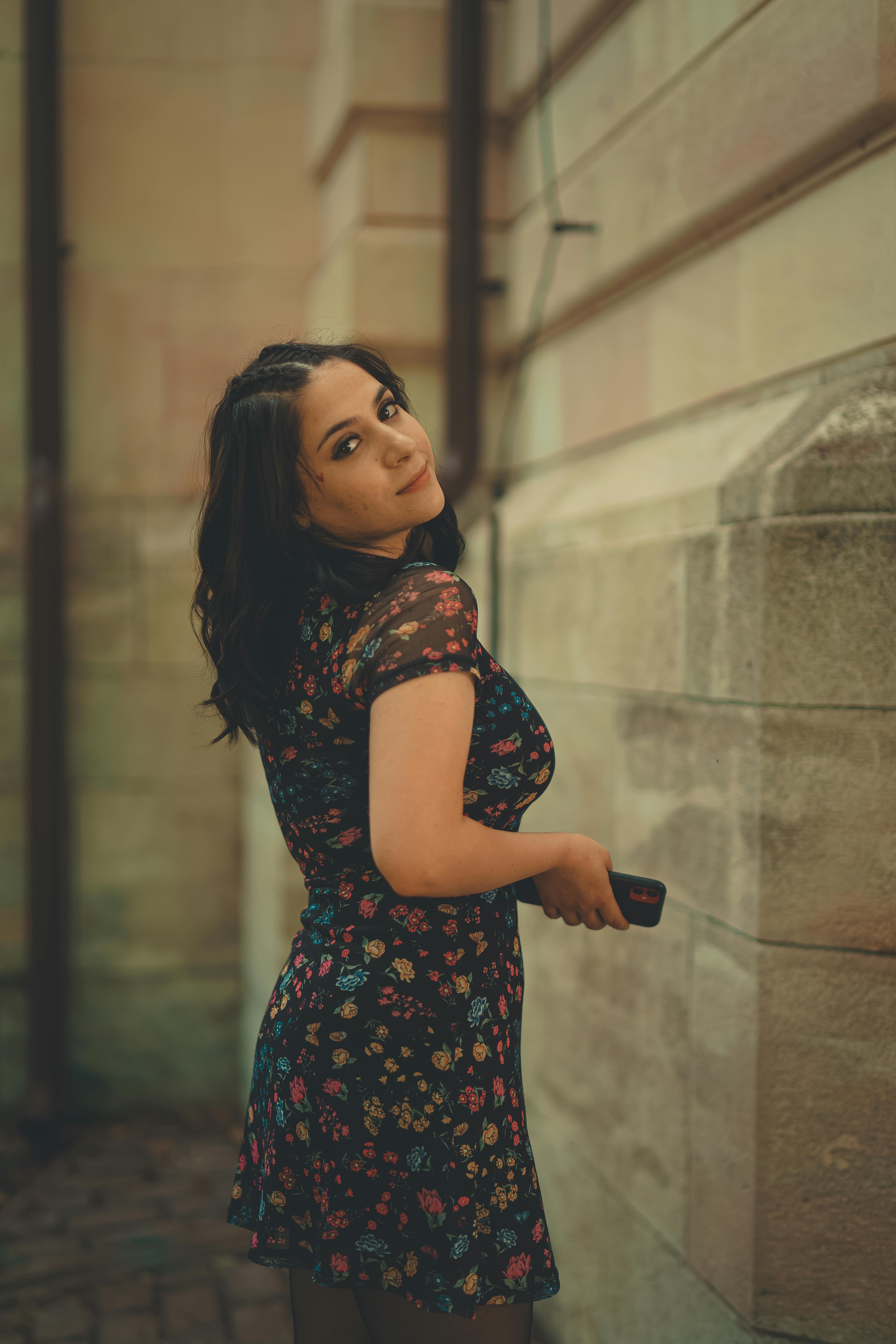 a woman in floral dress looking over shoulder