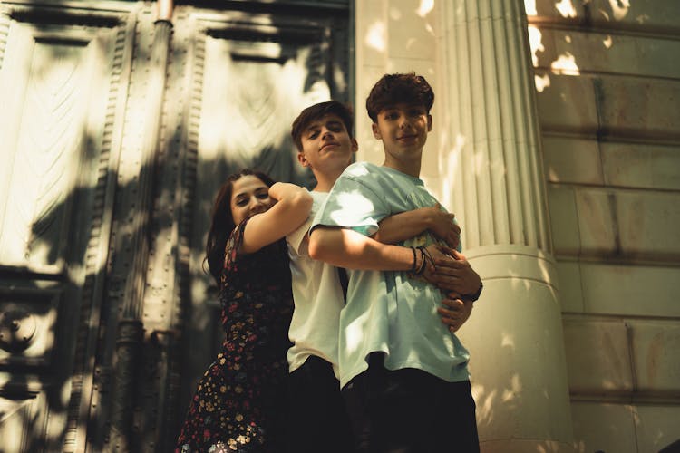 Photo Of Two Boys And A Girl Standing And Hugging