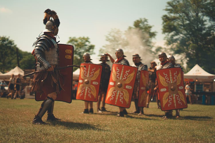 Men In Gladiator Costumes With Shield And Weapons