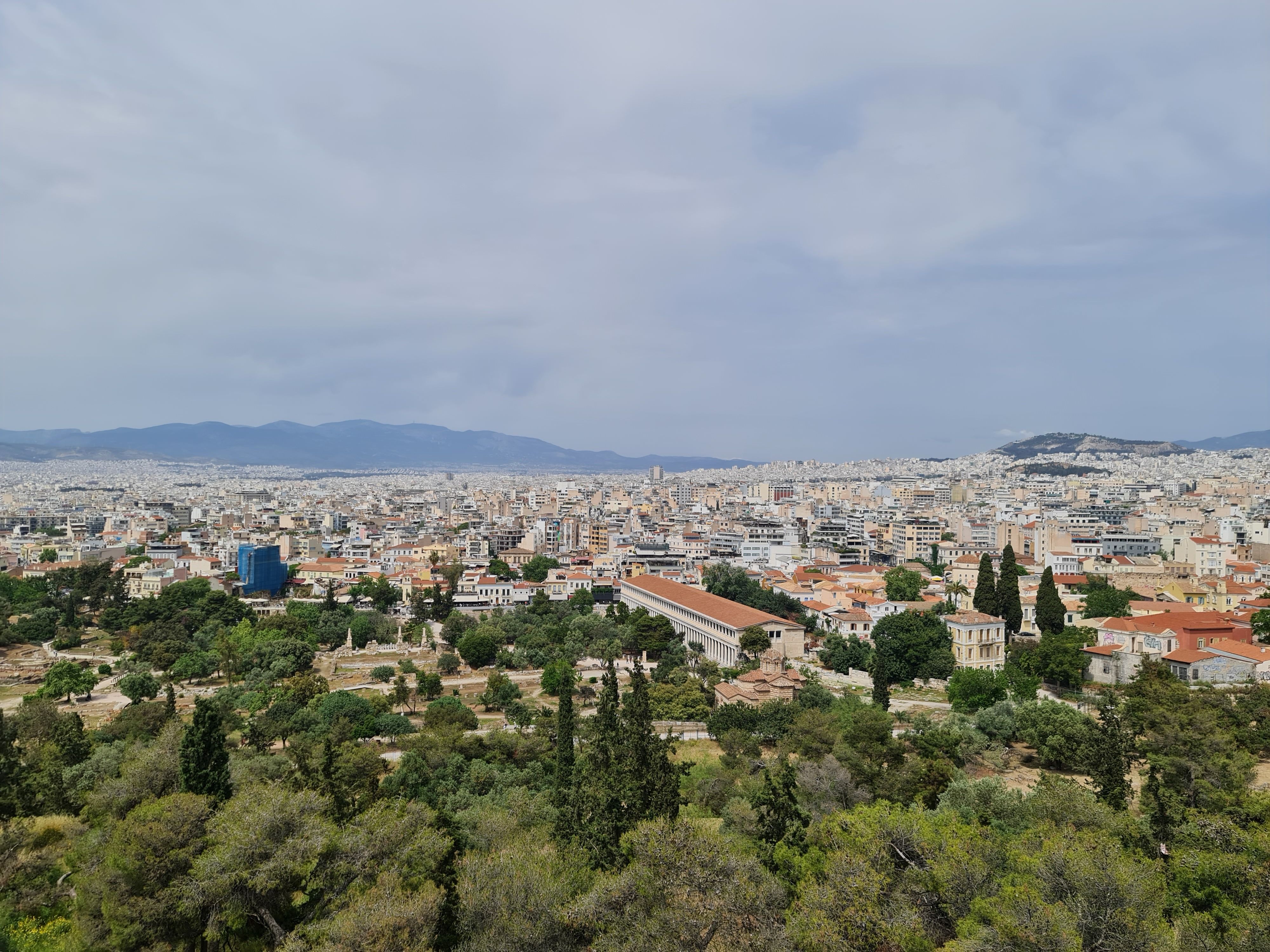 Aerial view of Athens showcasing cityscape, historical landmarks, and lush greenery.