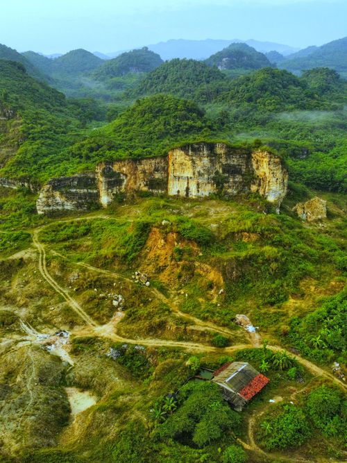 Free Breathtaking aerial shot of verdant hills and rugged cliffs, showcasing untouched nature. Stock Photo