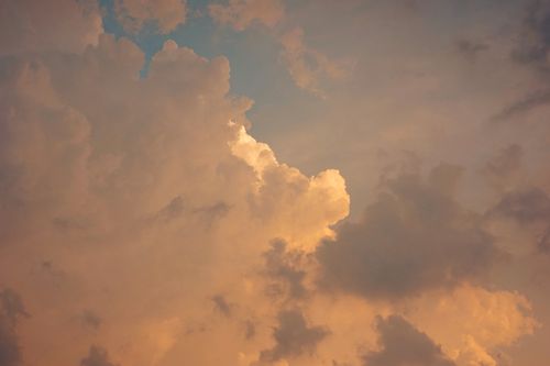 Free Stunning golden hour sky filled with fluffy, layered clouds in a captivating sunset scene. Stock Photo