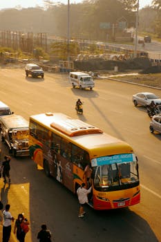 Commuters and vehicles in bustling traffic on Quezon Avenue during sunset.