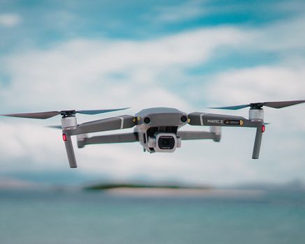 Close-up of a drone in flight over a serene beach in Indonesia.