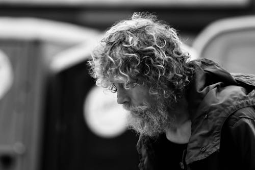 Grayscale Photo of an Elderly Man with Curly Hair