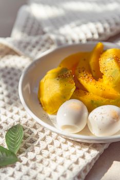 Delicious breakfast plate with boiled eggs and sliced yellow bell peppers in natural lighting.