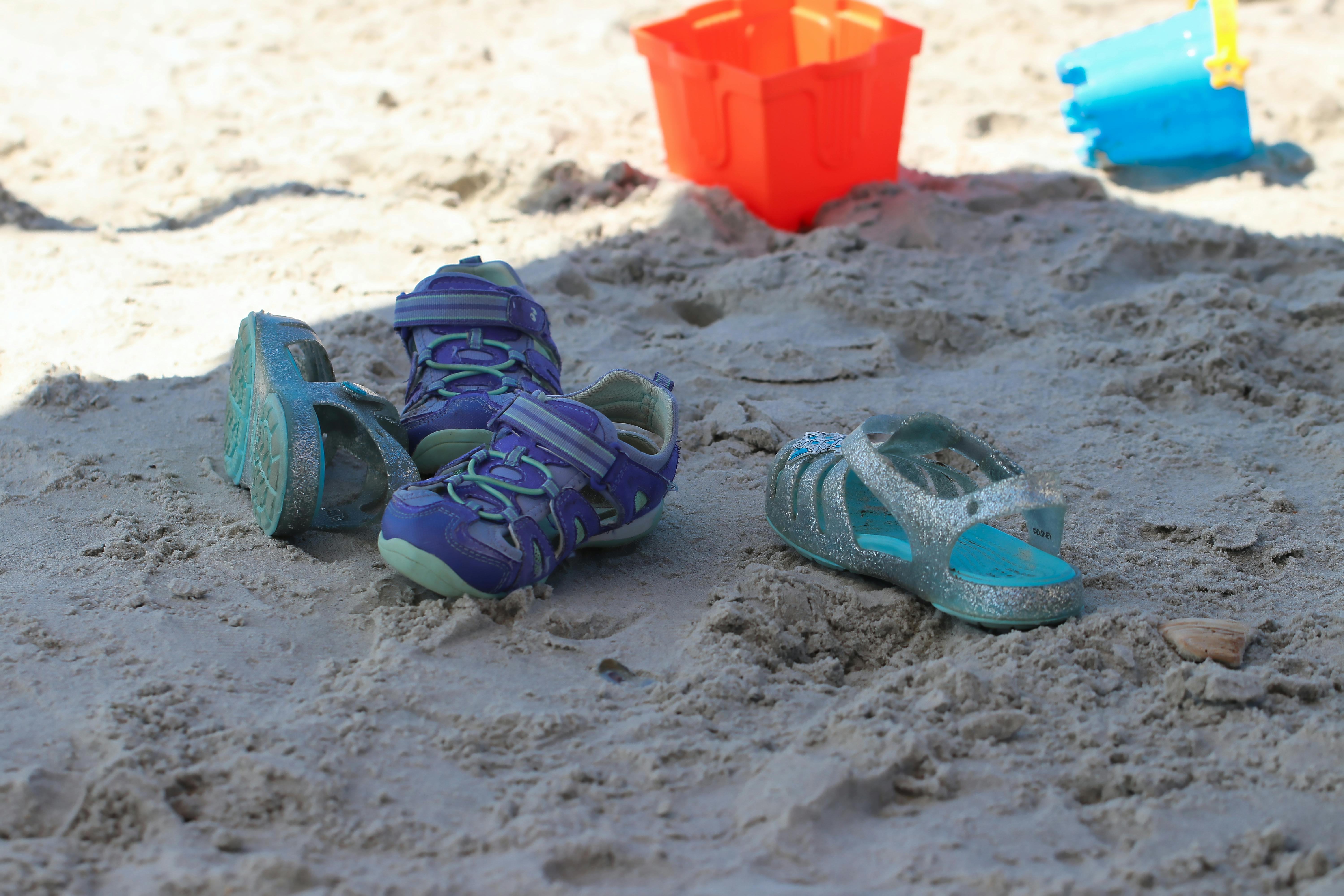 Free stock photo of beach, children\'s shoes, sand toys