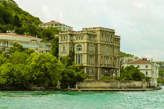 Elegant historic mansion overlooking the Bosphorus, surrounded by lush greenery.