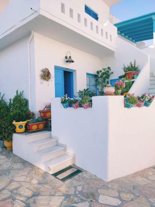 Free Beautiful Mediterranean villa with blue doors and colorful potted plants. Stock Photo