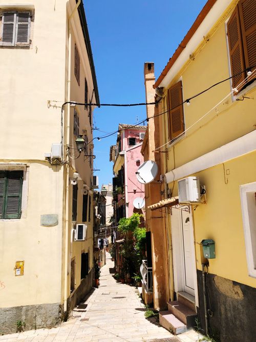 Free Picturesque narrow alleyway in Corfu, Greece, showcasing traditional architecture under bright sunlight. Stock Photo