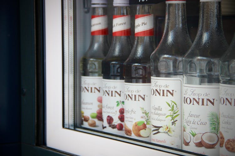 Close-up Of Flavored Syrups In Glass Bottles Standing In A Row