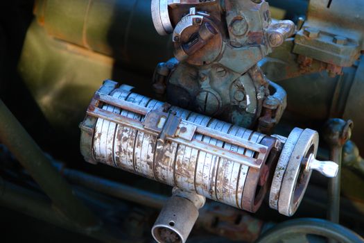Detailed view of a rusty, vintage industrial machine component in a workshop setting.