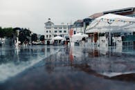 雨天，潮湿的城市景观中倒映着雨伞和节日帐篷