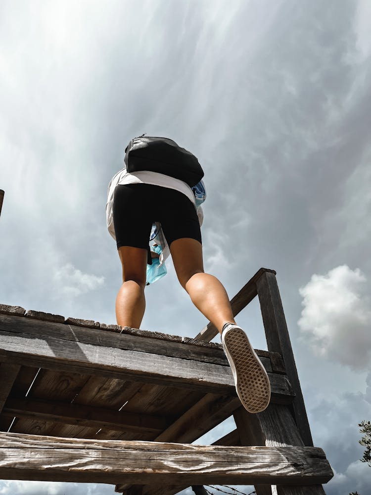 A Person Climbing A Wooden Post