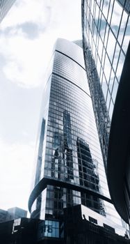 Low angle shot of a futuristic skyscraper reflecting blue skies in Moscow.