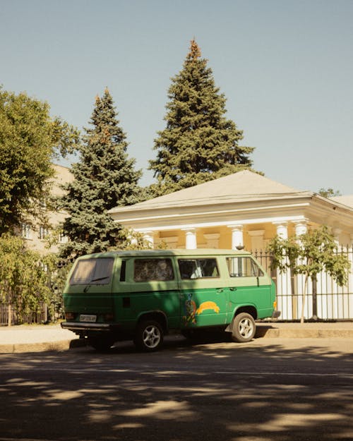 Free Green Van Parked Outside the House Fence Stock Photo