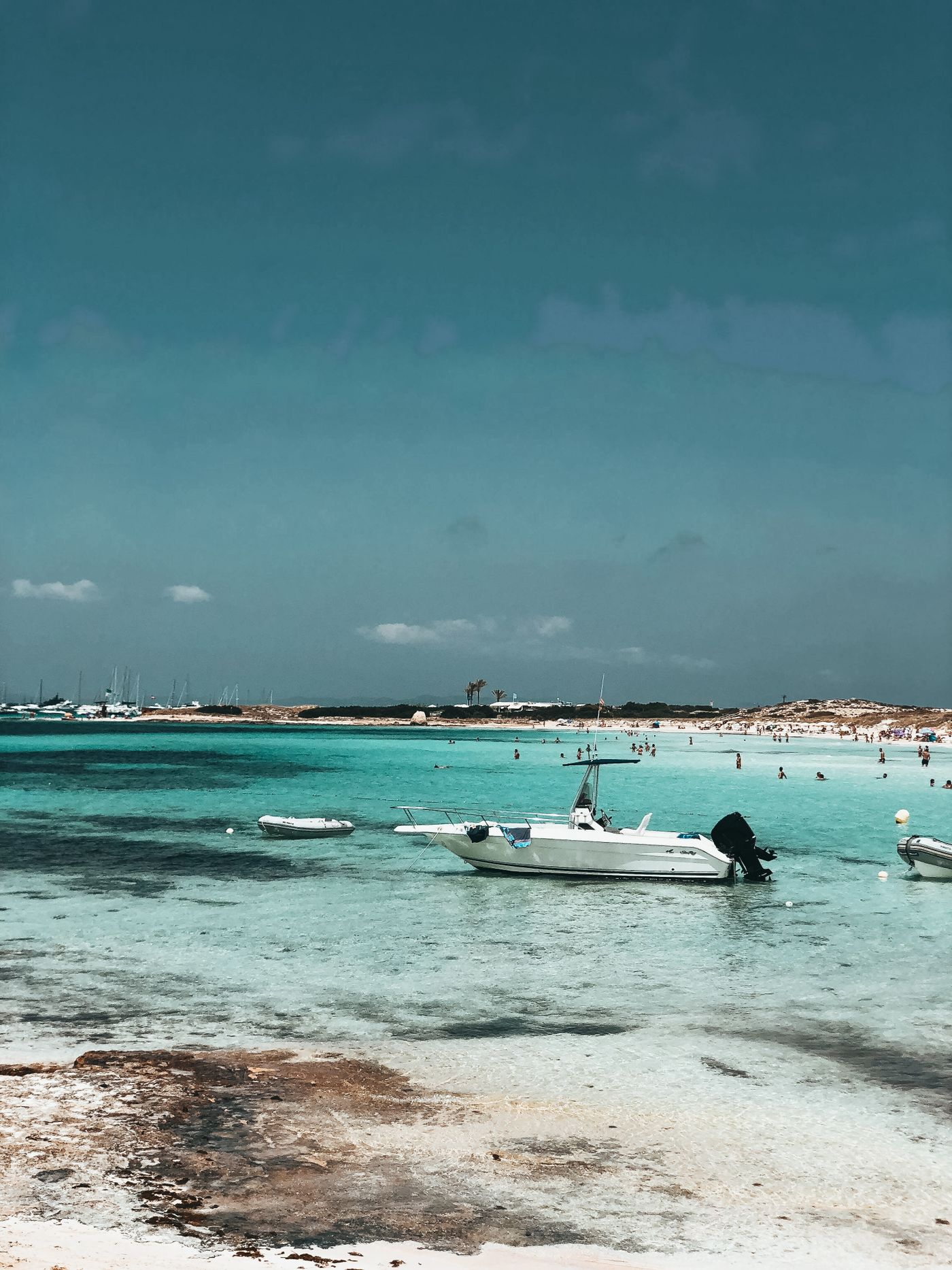 White motorboat anchored in turquoise water off Formentera