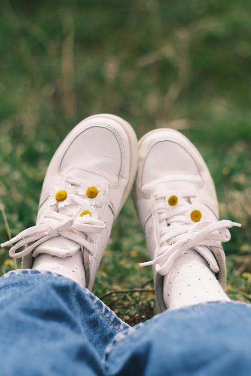 White Sport Shoes on Feet of Person Sitting on Grass