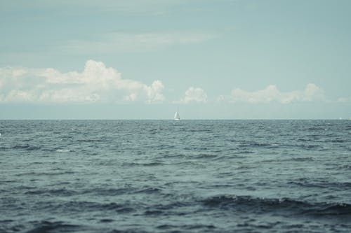 White Sailboat on Sea Under Blue Sky