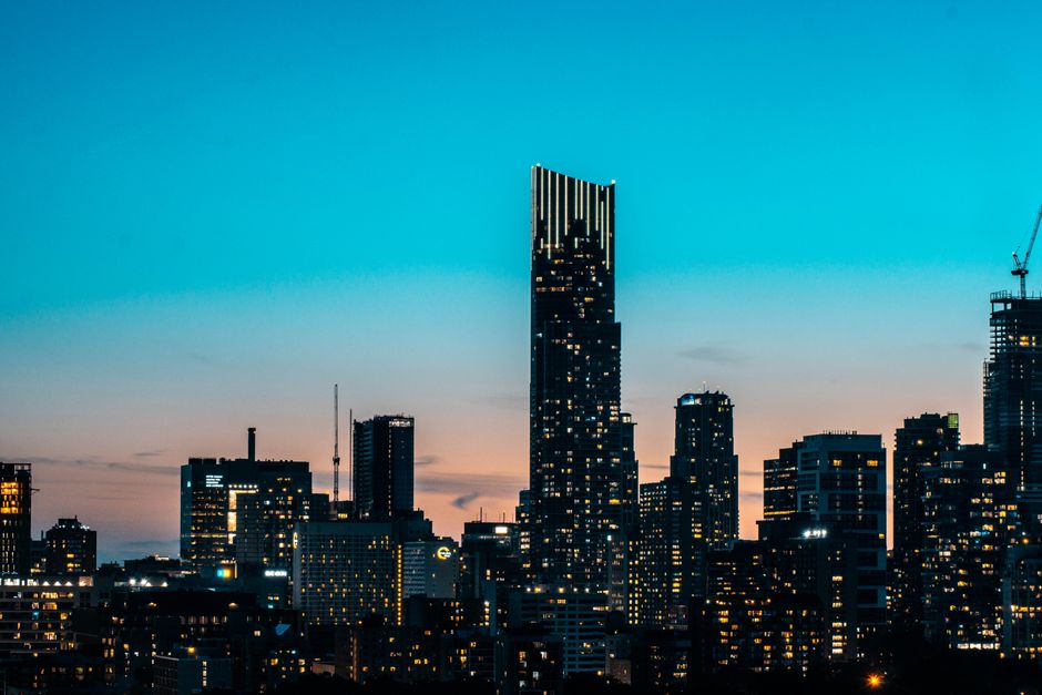 Stunning view of Toronto skyline with skyscrapers illuminated at night against a twilight sky.