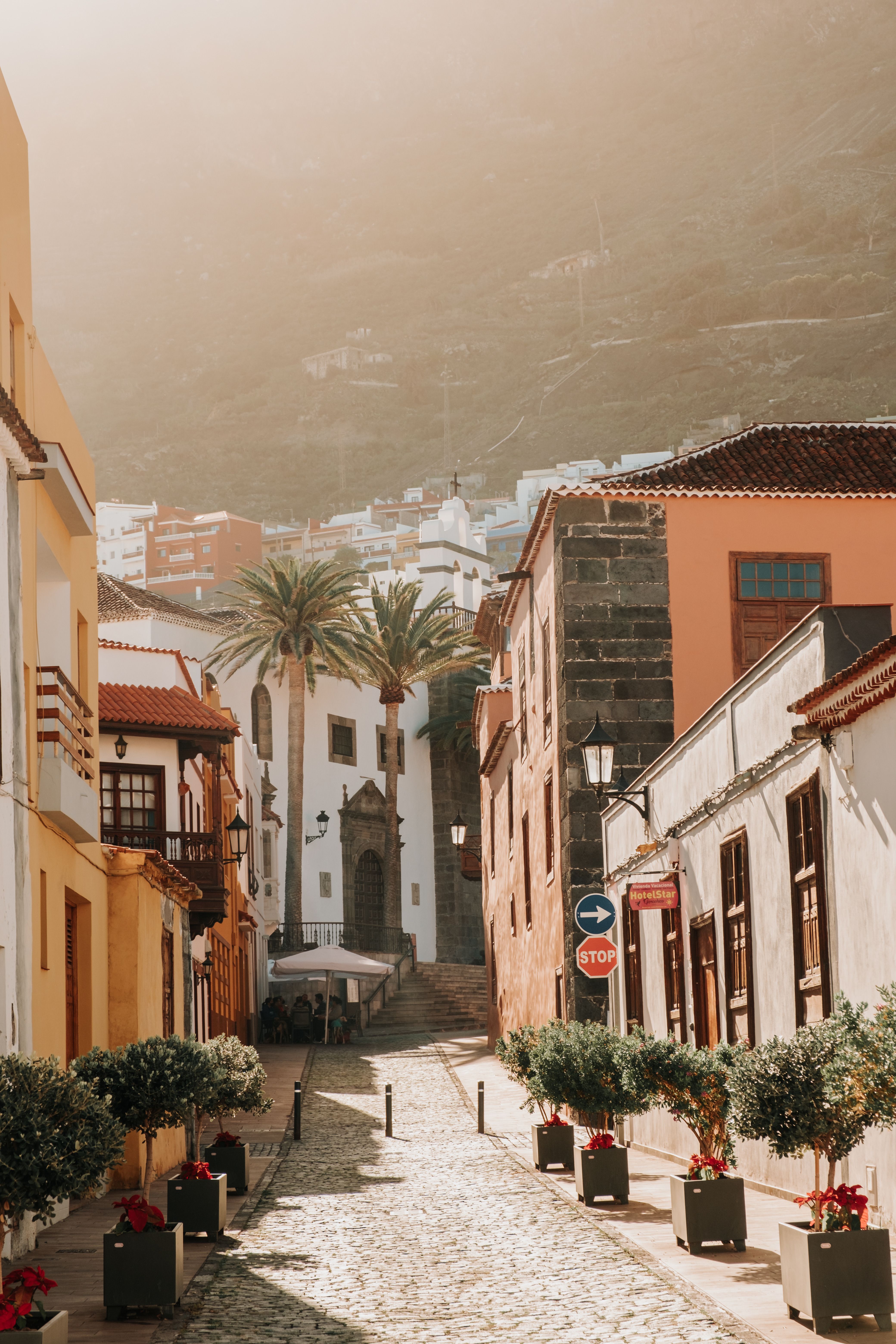 Narrow cobblestone street leading to a historic building on a sunny day in a picturesque village.