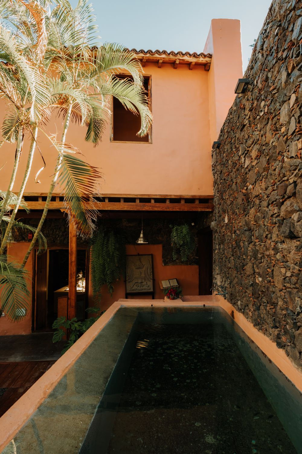 Outdoor natural stone wall beside a landscaped pool