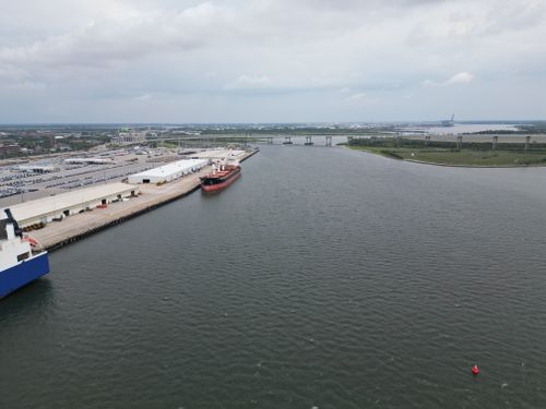 Free Aerial photo showcasing the busy port of Charleston, SC with cargo ships and docks. Stock Photo