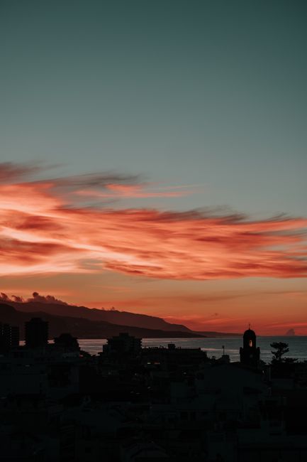 Dramatic city silhouette against a vivid sunset sky with colorful clouds.