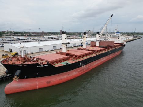 Aerial view of cargo ship Adelina at Charleston port, showcasing industrial harbor life.