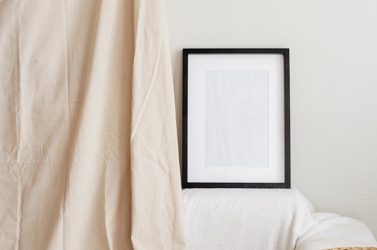 An Empty Picture Frame On A White Wall