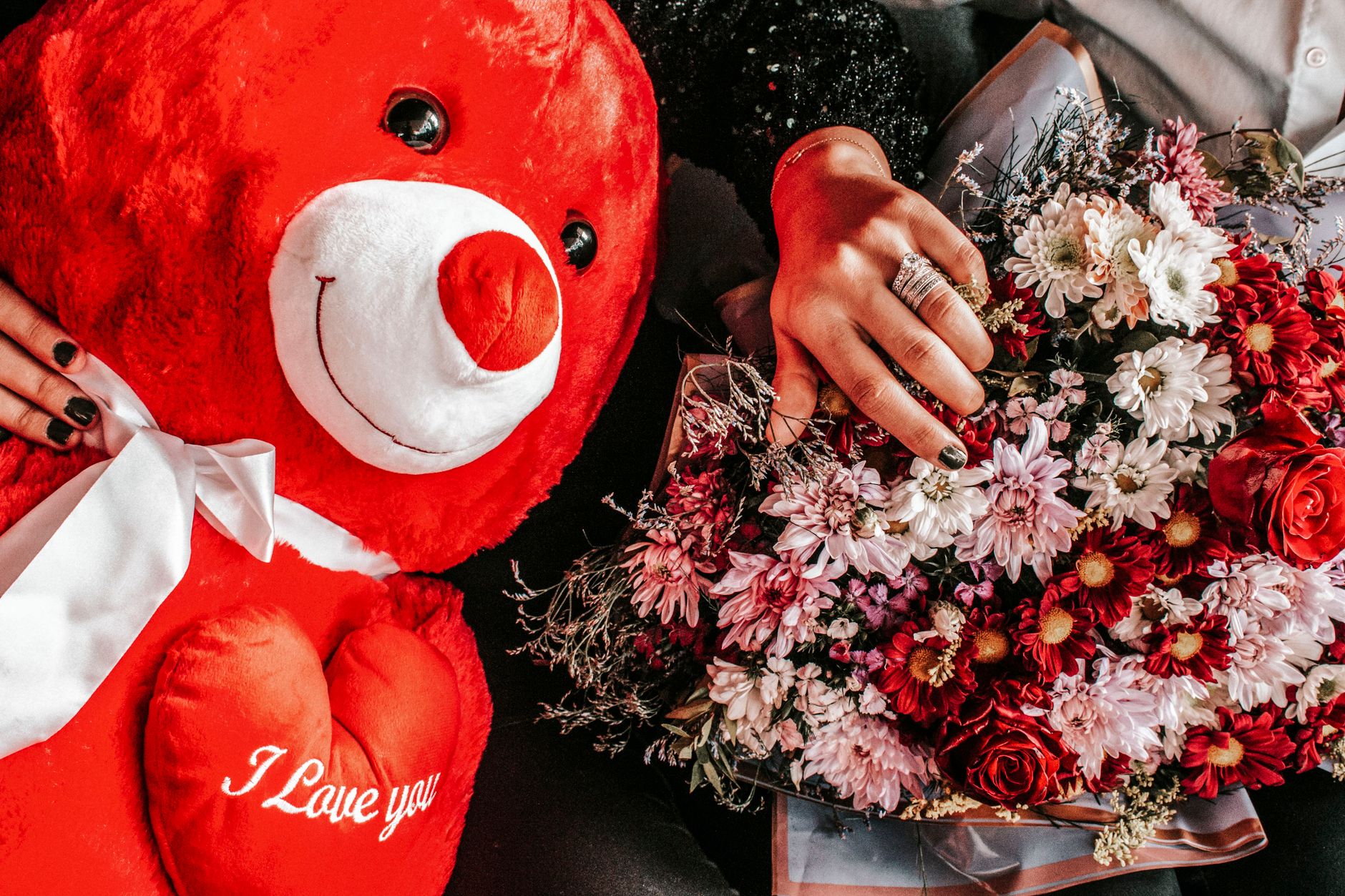 Bright red teddy bear and colorful flower bouquet, perfect for romance and celebration.