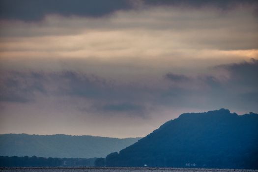 A tranquil overcast view of Lake City, Minnesota, featuring peaceful hills and cloudy skies.