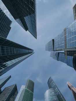 Low angle view of modern skyscrapers against a clear blue sky, emphasizing urban architecture.