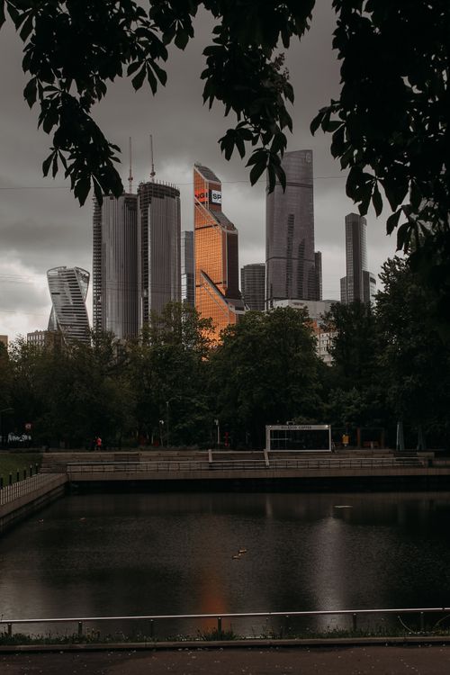 Free Dramatic view of Moscow's skyscrapers with reflective glass and a park foreground. Stock Photo