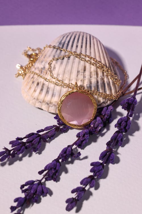 A Necklace with Pink Gemstone Pendant on Seashell