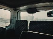 Van interior overlooking cityscape in Iraq during daytime, highlighting empty seats.