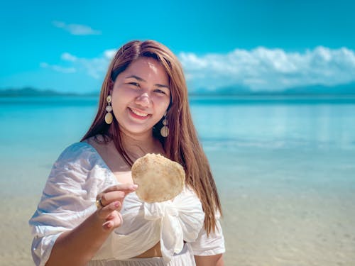 A Woman Holding a Seashell
