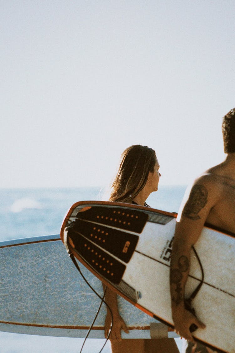 Man And Woman Holding Surfboards