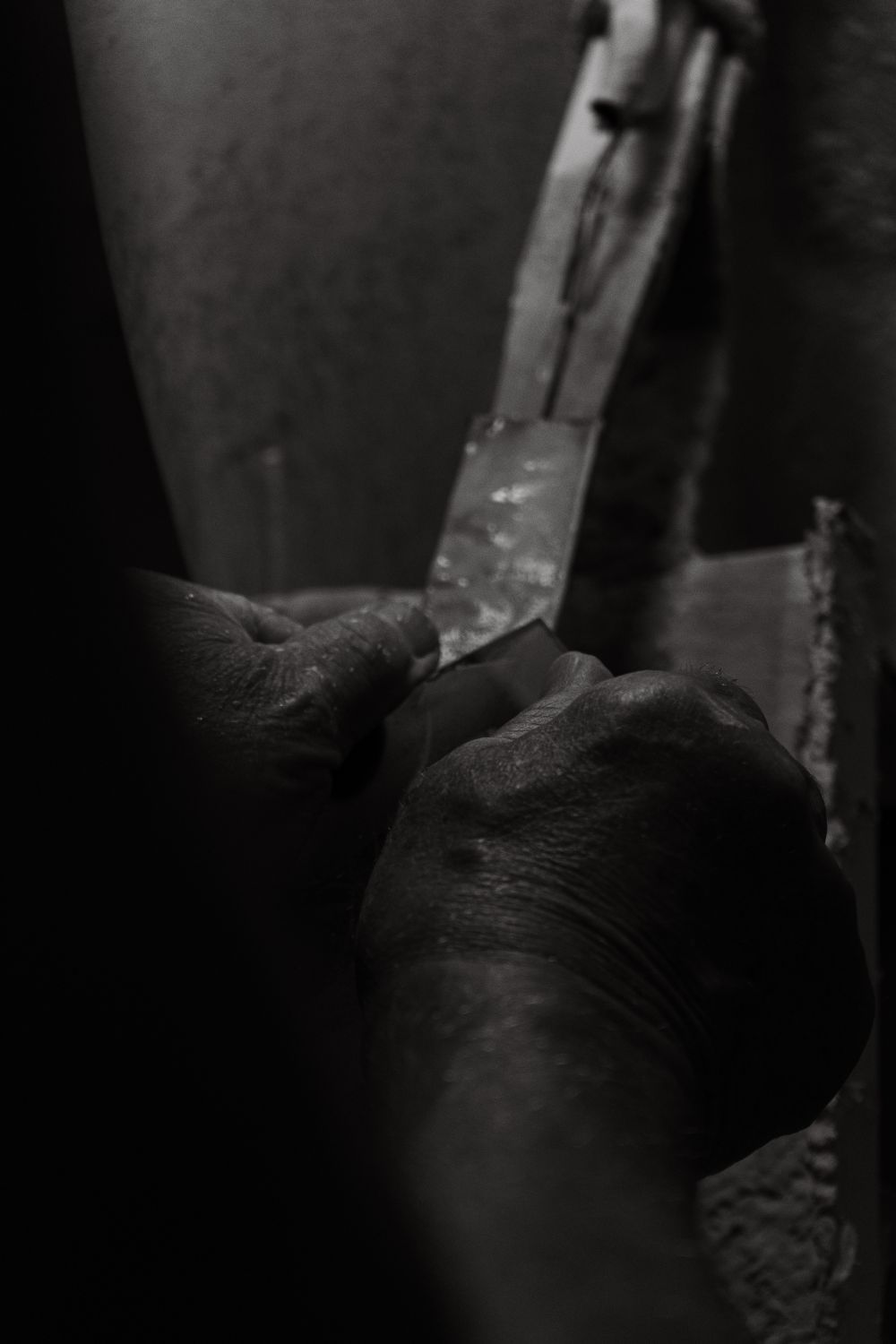 Hands working on a craft in moody black and white