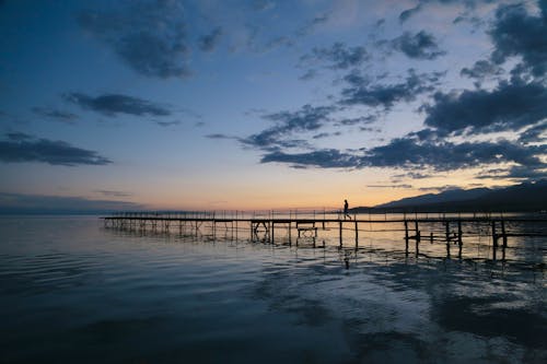 Photo of Person Walking on Dock