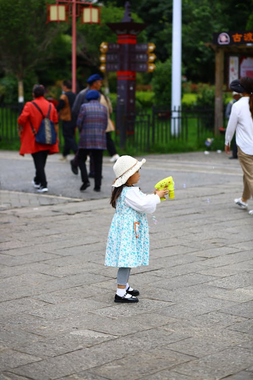 Girl Wearing Hat Holding a Toy