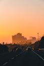 Cars on Road Near City Buildings during Sunset