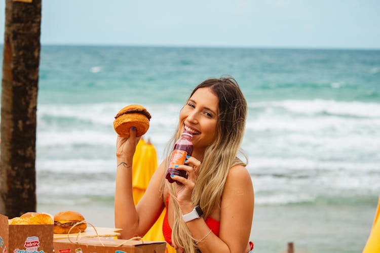 Woman Holding A Burger And A Drink