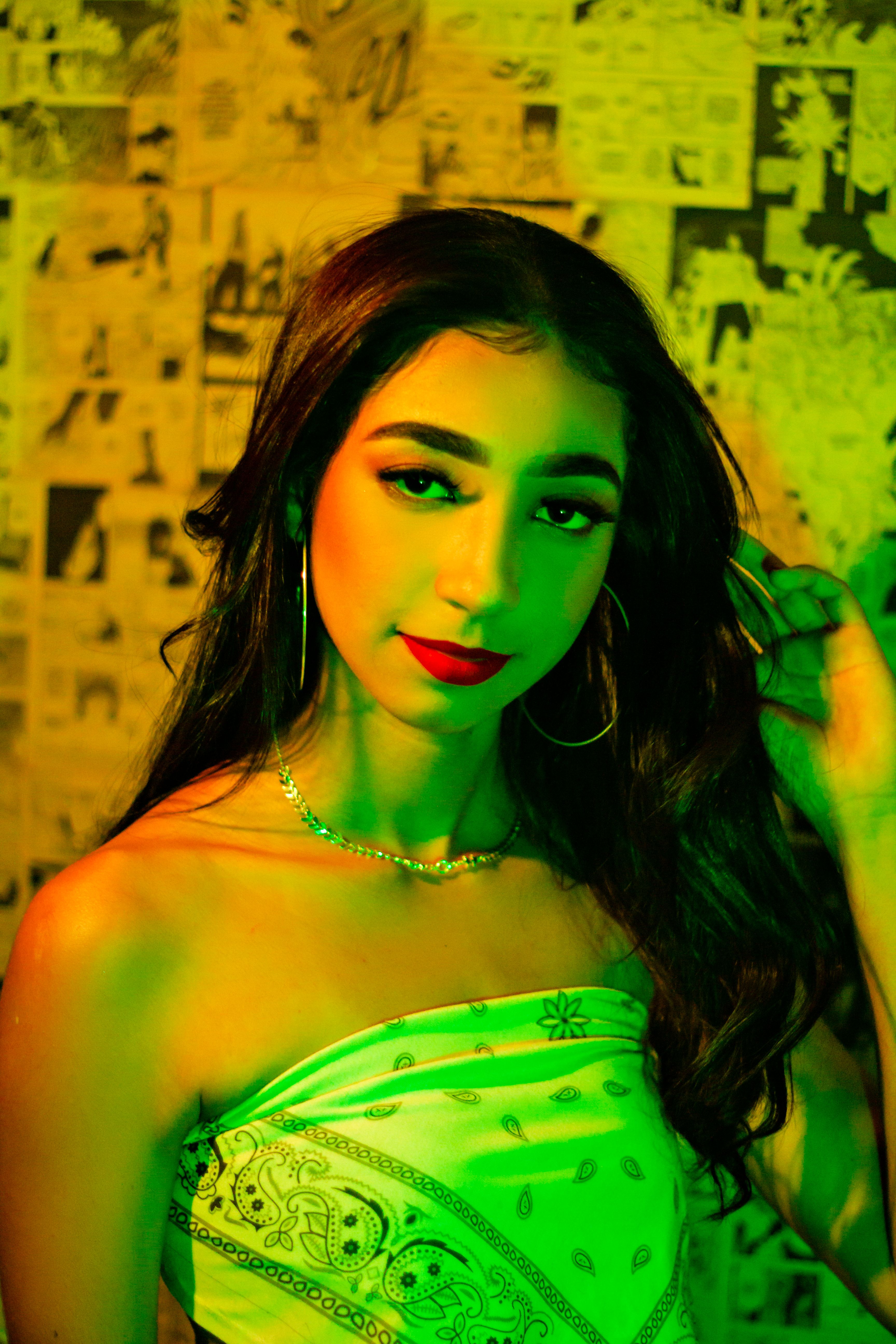 Portrait of a woman with red lips and hoop earrings against a comic book background.
