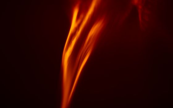 A vivid abstract image capturing the dynamic movement of a flame in warm hues.