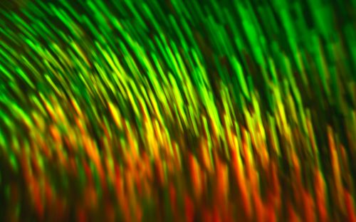 Free Vibrant abstract pattern with green and orange motion blur, creating a vivid and dynamic texture. Stock Photo